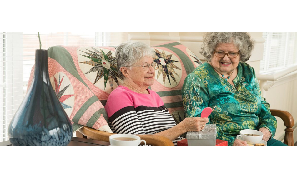 Image of two women, sitting in our retirement home enjoying the amenities