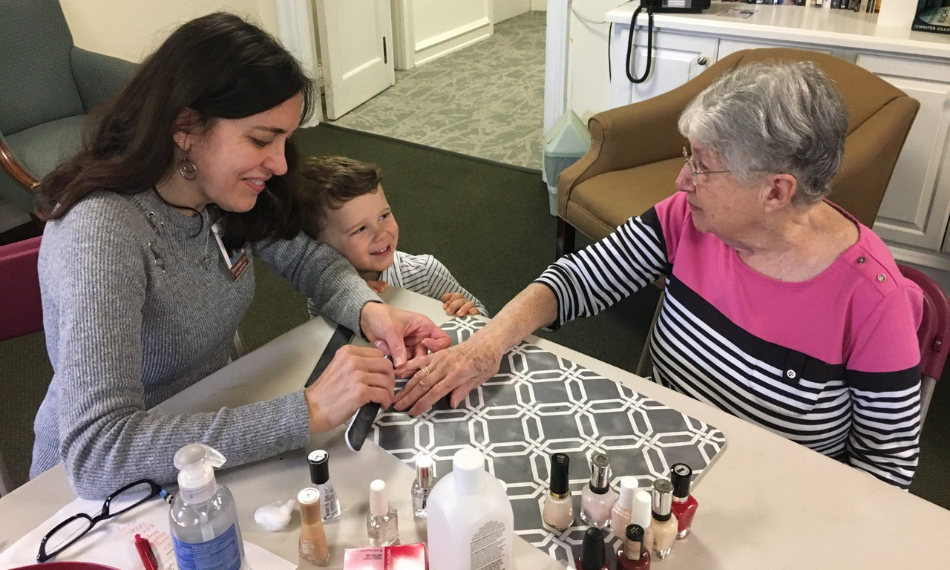 Image of an older woman getting a manicure with a child watching.